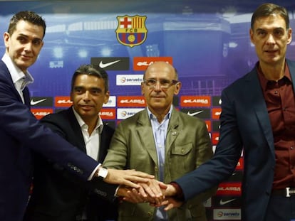 Rodrigo de la Fuente, Albert Soler, Joan Blad&eacute; y Georgios Bartzokas juntan sus manos durante la presentaci&oacute;n del nuevo t&eacute;cnico del equipo de baloncesto.