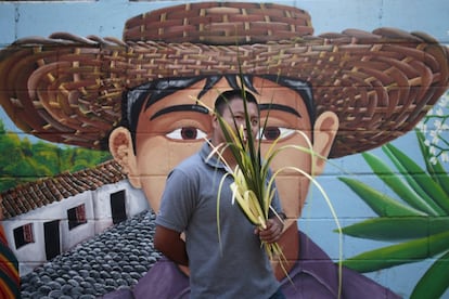 Un hombre sostiene hojas de palma durante la celebración del Domingo de Ramos en Nahuizalco, El Salvador.