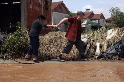 Dos mujeres se ayudan a cruzar una calle inundada. El presidente del país, Gjorge Ivanov, visitó el lugar y dijo que "nunca había ocurrido un desastre de este tipo" en Skopie.