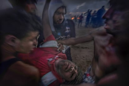 Un palestino inconsciente, herido por un francotirador en la primera línea de la valla, es evacuado a pulso por sus amigos. Moría poco después (Gaza).