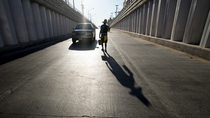 Un lavador de vidrios se acerca a un auto que espera cruzar la frontera hacia California, en Mexicali (México).