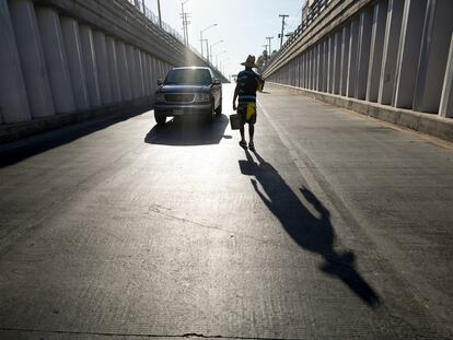 In Mexicali – a city in Baja California, Mexico – a window washer approaches a car, which is waiting to cross the border into California.