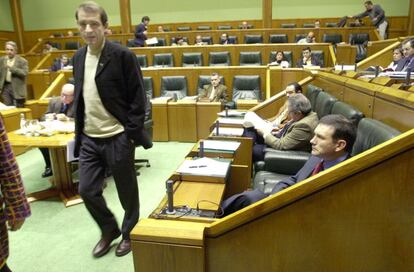 Josu Ternera, parlamentario de Euskal Herritarrok, pasa frente al lehendakari Juan José Ibarretxe (sentado), durante un pleno sobre la violencia de ETA en 2000.