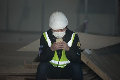 A worker looks at his cellphone in Barcelona, last February.