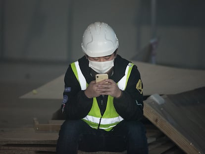 A worker looks at his cellphone in Barcelona, last February.