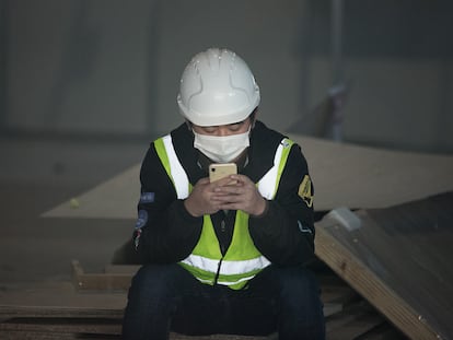 Un trabajador consulta su móvil en Barcelona, el pasado febrero.