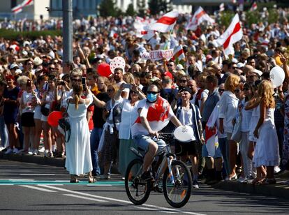 Un manifestante pasa en bicicleta junto a la concentración opositora en el centro de Minsk.