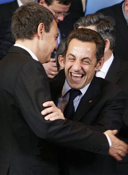 Zapatero y Sarkozy se abrazan durante la reunión del Consejo Europeo.