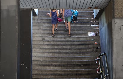 Dos personas suben las escaleras en uno de los subterráneos de los bajos de Azca, en las que se acumula basura y desperdicios.