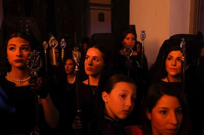 Mujeres con mantillas pertenecientes a la hermandad del Huerto, esperan dentro de una iglesia para participar en una procesión en Ronda, este lunes.