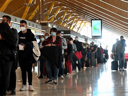 Decenas de pasajeros hacen cola para pasar controles adicionales por la pandemia, en la T4 del aeropuerto de Adolfo Suárez-Barajas este viernes.