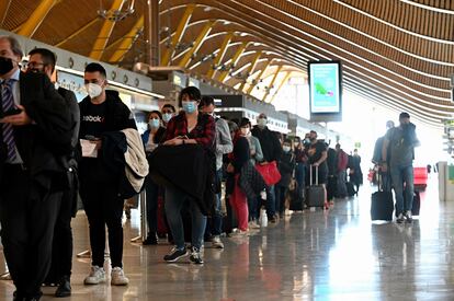 Decenas de pasajeros hacen cola para pasar controles adicionales por la pandemia, en la T4 del aeropuerto de Adolfo Suárez-Barajas este viernes.