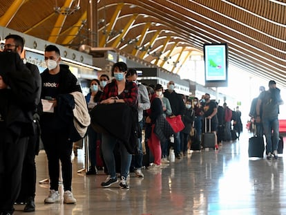 Decenas de pasajeros hacen cola para pasar controles adicionales por la pandemia, en la T4 del aeropuerto de Adolfo Suárez-Barajas este viernes.
