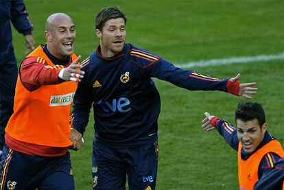 Pepe Reina y Xabi Alonso bromean con Cesc durante el entrenamiento.