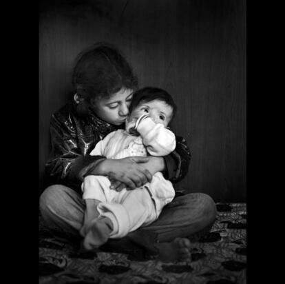 Mayam, de ocho años, cuida a su hermana pequeña, Safa, que nació en el campo de refugiados jordano de Zaatari hace ocho meses.