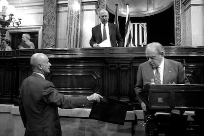 Josep Antoni Duran i Lleida (a la izquierda) entrega la cartera a Jordi Pujol al término del discurso del presidente de la Generalitat en el debate de Política General, ante la mirada del presidente del Parlament, Joan Rigol, el 3 de octubre del 2000.
