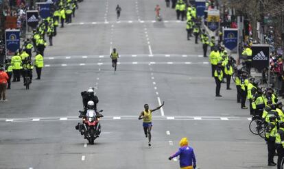 Lelisa Desisa saluda victorioso en la recta final de la maratón, donde hubo gran presencia policial.