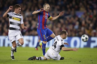 Andres Iniesta, intenta salir ileso de la entrada Tony Jantschke.