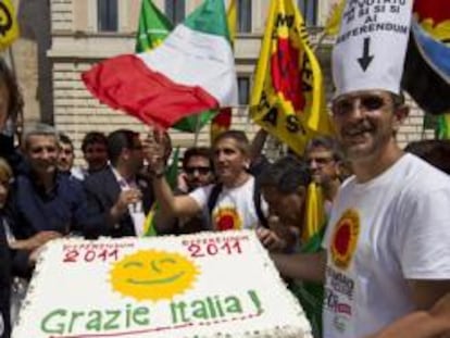 Angelo Bonelli, presidente del partido italiano de los Verdes, recibe una tarta de regalo mientras celebra los resultados del referendo sobre la energía nuclear