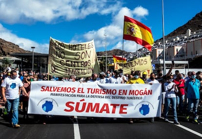 La decisión de alojar migrantes en los hoteles ante la situación de emergencia y la falta de otros alojamientos ha permitido salvar de la quiebra a varios complejos y ha sacado del ERTE a decenas de personas. Pero también generó desconcierto y enfado en parte de la población local y tuvo en contra, desde el primer día, a la alcaldesa de Mogán, uno de los principales municipios turísticos de Gran Canaria, Onalia Bueno. La primera manifestación contra la ocupación de complejos hoteleros por migrantes la convocó la Plataforma Salvemos el Turismo de Mogán. Los manifestantes defendieron que la acogida de extranjeros sin papeles en sus establecimientos –y no la crisis sanitaria de la covid– ahuyentaría a los turistas