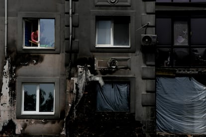 Una mujer limpia una ventana de su casa destruida por los bombardeos, en Bucha, en las afueras de Kiev, Ucrania, este miércoles.