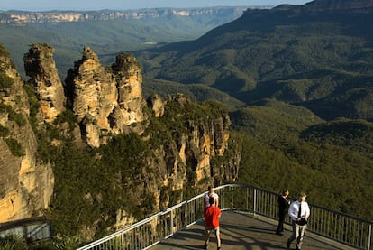 A menos de dos horas en coche o en tren de Sídney se extiende uno de los parques nacionales más espectaculares de Australia, el de las Montañas Azules. Su nombre deriva de la bruma azulada que envuelve su paisaje, producida por los aceites que los bosques de eucaliptos que lo alfombran liberan en la atmósfera. Cañones, valles profundos, cascadas de agua y la famosa formación rocosa de Las Tres Hermanas (en la imagen), con leyenda incluida: tres hermanas de la tribu katoomba, Wimlah, Meehni y Gunnedoo, convertidas en piedra por enamorarse de quienes no debían.