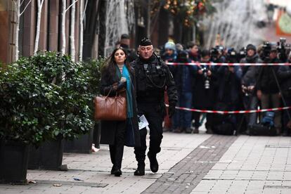 Un policía escolta a una mujer a su paso por la zona donde se produjo un ataque en Estrasburgo (Francia). La Fiscalía investiga el suceso como un posible atentado terrorista.