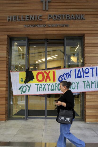 Una mujer ante la sede de Hellenic Postbank, la caja postal griega, durante una protesta convocada contra su privatización.