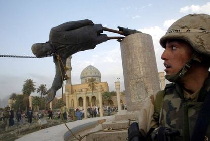 Un soldado estadounidense observa cómo derriban la estatua del presidente iraquí Sadam Husein, en abril de 2003.