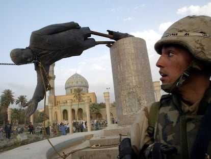 Un soldado estadounidense observa cómo derriban la estatua del presidente iraquí Sadam Husein, en abril de 2003.