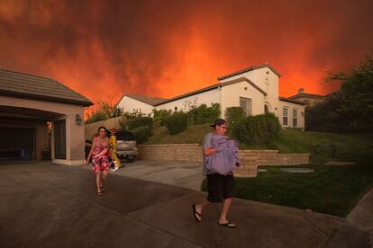 Una familia abandona su casa durante el incendio forestal en Santa Clarita, California, el 24 de julio de 2016.