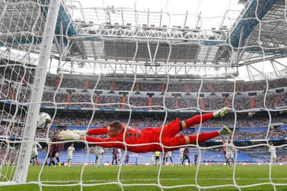 El portero del Real Madrid, Andriy Lunin, detiene el balón.