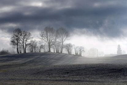 Nubes oscuras sobre prado nevado cerca de Nesselwang (Alemania).