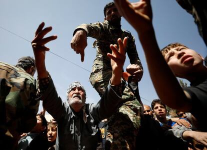 Un hombre que ha huido de Guta Oriental alza sus manos para pedir ayuda a las fuerzas rusas en un refugio en Adra, cerca de Damasco (Siria).