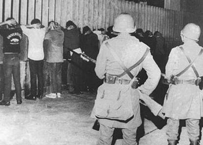 En una fotografía de 1971, dos policías mexicanos vigilan a varios estudiantes detenidos en una redada.