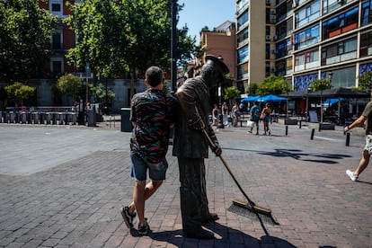 Daniel P. reposa sobre la escultura del 'Barrendero madrileño', en la plaza Jacinto Benavente de Madrid.