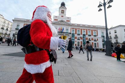 Un hombre disfrazado de Papá Noel en la Plaza del Sol de Madrid.