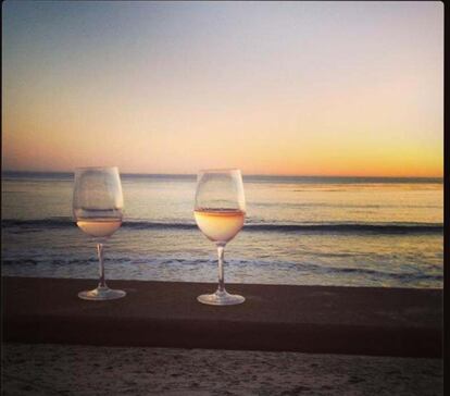 Dos copas de vino con el mar de fondo. ¿Quién se esconde tras esta soñada instantánea? Poppy Delevigne y una de las playas de Malibú.