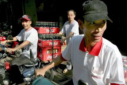 Distribuidores de Coca Cola cargan sus motos en Hanoi, Vietnam.