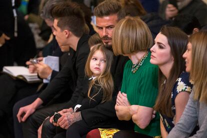 David Beckham speaks with Anna Wintour as his daughter, Harper, sits on his lap during a presentation of the Victoria Beckham Fall/Winter 2015 collection during New York Fashion Week