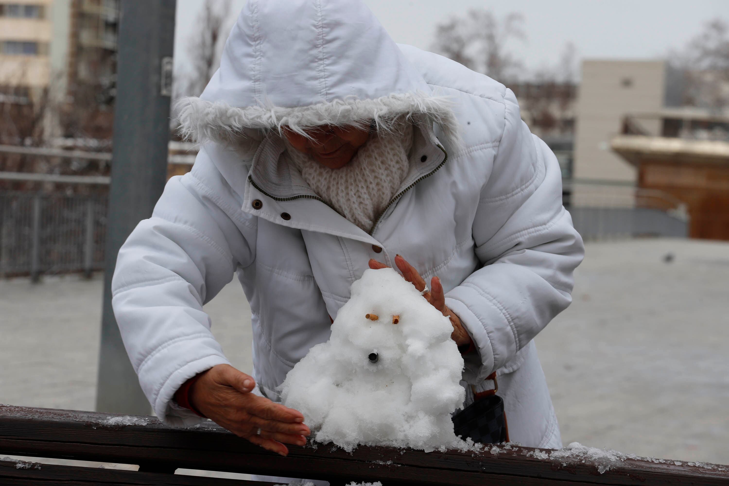 Una mujer hace un muñeco de nieve, este lunes en Terrassa. 