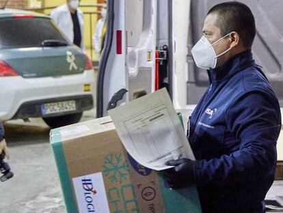 Un operario recoge la caja con las dosis de la vacuna desarrollada por los laboratorios Pfizer y BioNtech para llevarla  a la residencia Los Olmos, donde se inicia la vacunación contra el COVID-19 en España.