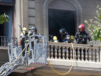 Bomberos extinguiendo el fuego del edificio.