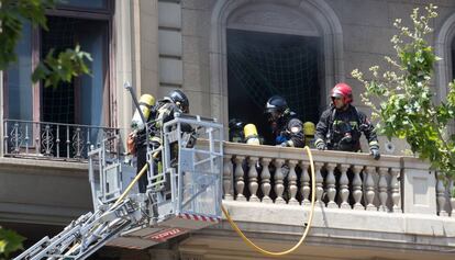 Bombers extingint el foc de l'edifici.