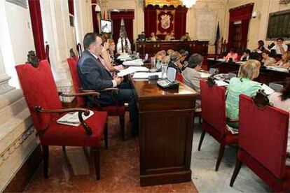 Los concejales de Málaga, junto al sillón de Rosa Agüera, vacío durante el pleno de ayer.