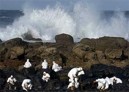 Un grupo de voluntarios procedentes de Madrid limpia rocas en la costa de Muxía ayer por la mañana.