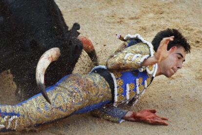 Juan Jiménez Fortes, perseguido en el suelo por uno de los novillos de su lote.