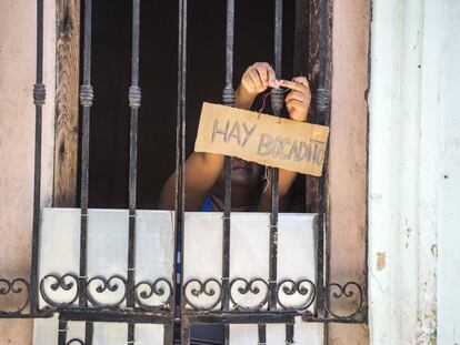 Una mujer ofreciendo comida en una casa de La Habana