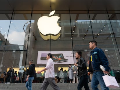 Consumidores chinos pasean frente a una tienda de Apple en Shanghái.