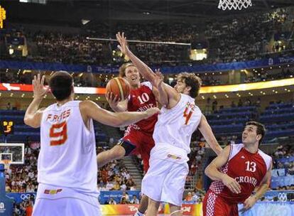 Pau Gasol y Felipe Reyes intentan frenar la entrada de Planinic.